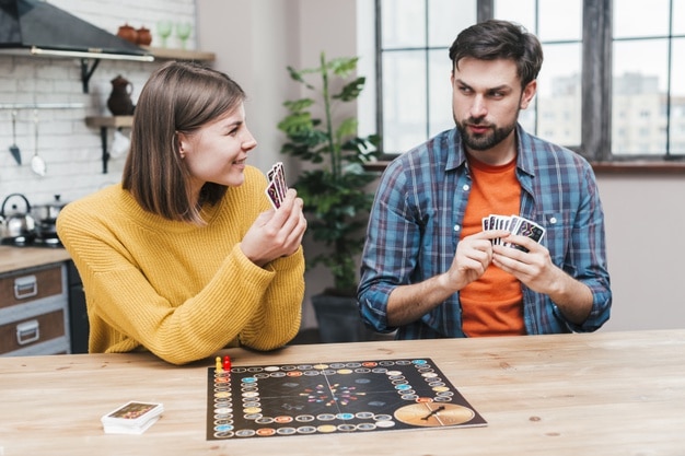 11 Wonderful Ways to Celebrate Valentine’s Day in 2021-young-couple-playing-board-game-kitchen_