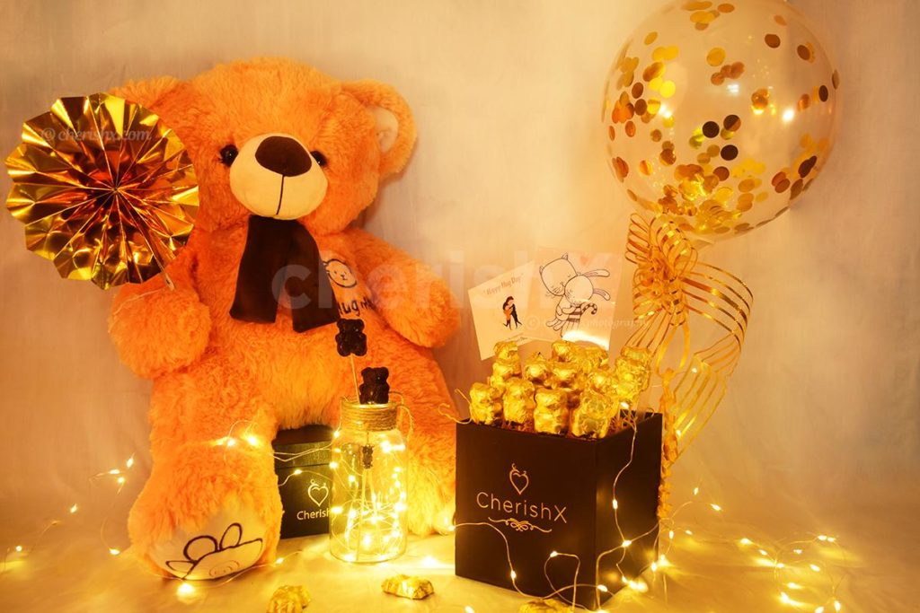 Teddy With Balloon Bucket consisting chocolates and a confetti balloon for teddy day celebration