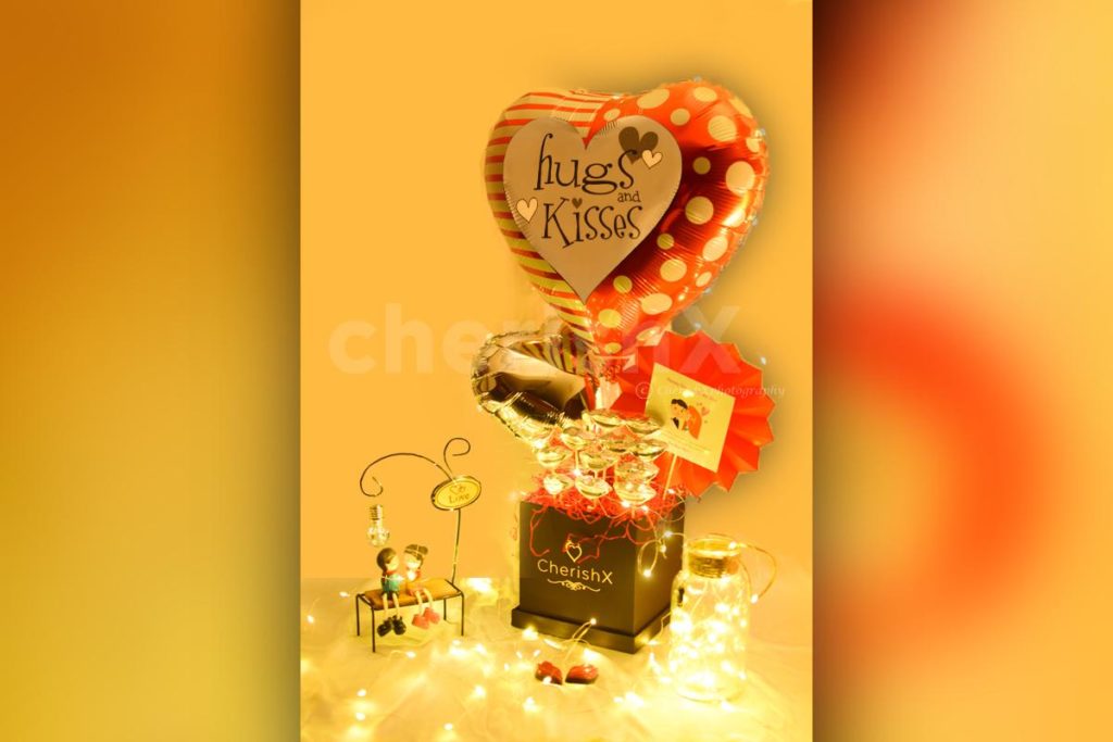 Hugs And Kisses Bucket for hug day celebration featuring a heart shaped foil balloon and chocolates 