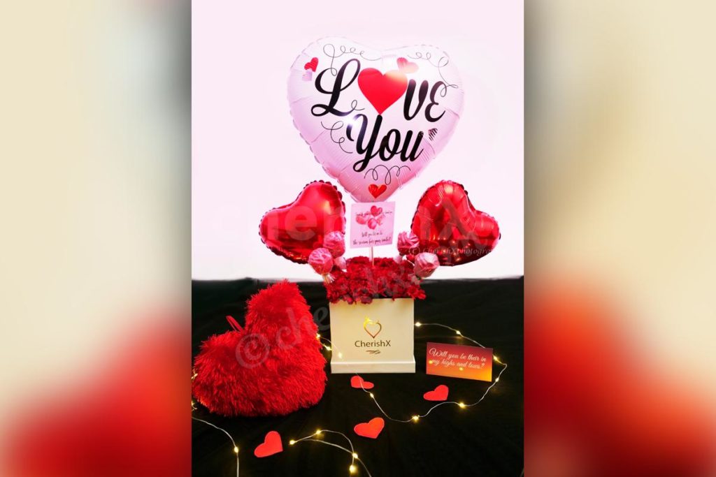 Red Carnations Love Balloon Bouquet featuring heart shaped foil balloons with chocolates for Valentine's