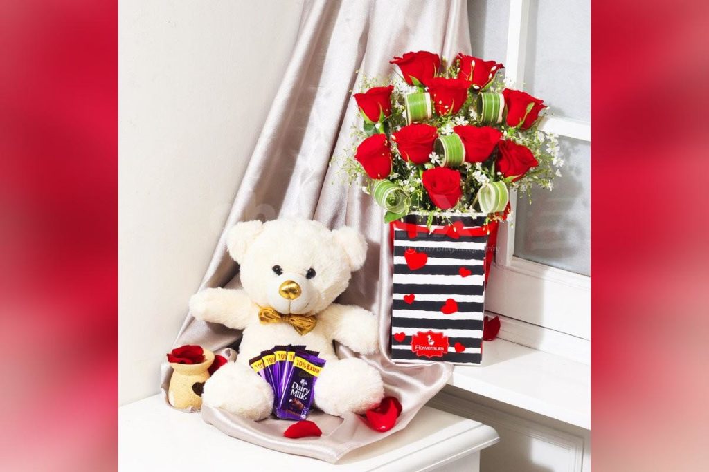Cuddle And Kisses Combo featuring a teddy bear and red roses with chocolates for hug day gifts 
