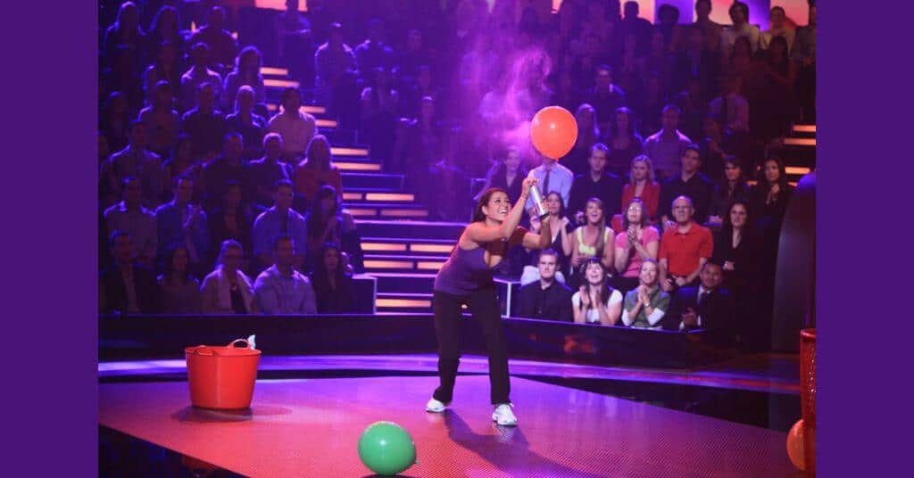 A woman playing spray the balloon game 
