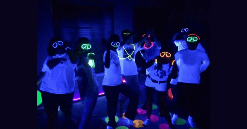People are wearing neon-friendly glasses and neck rings for the party.
