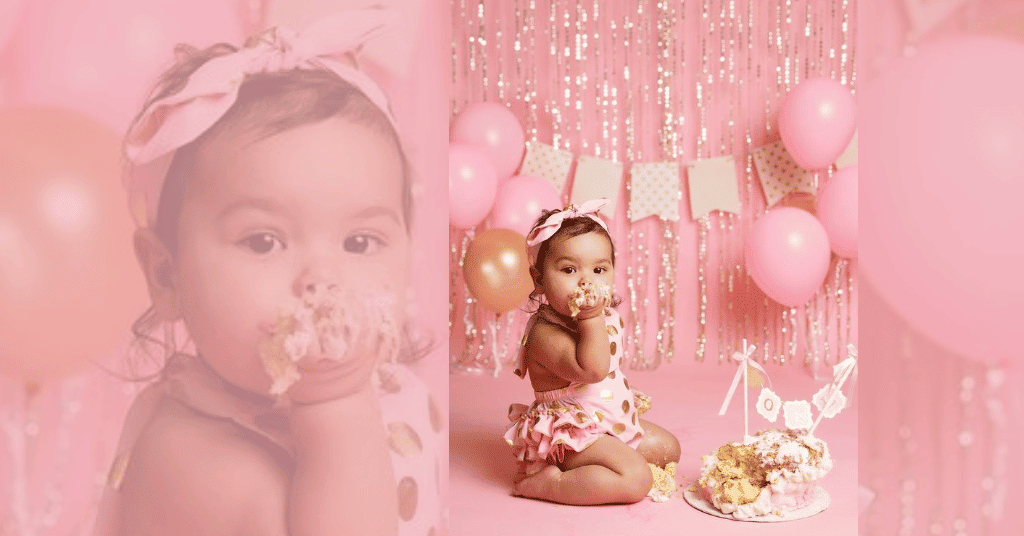 Baby enjoying cake amidst frill curtain and balloons on her 1st birthday. 