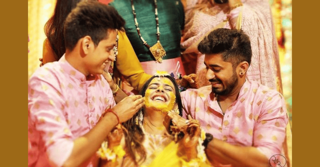 brother's applying Haldi on their sister's face